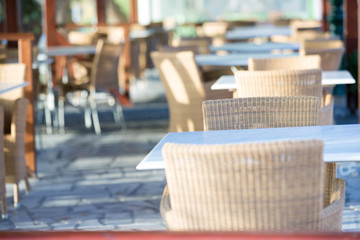 Tables and chairs in a street restaurant in Kamari on Santorini