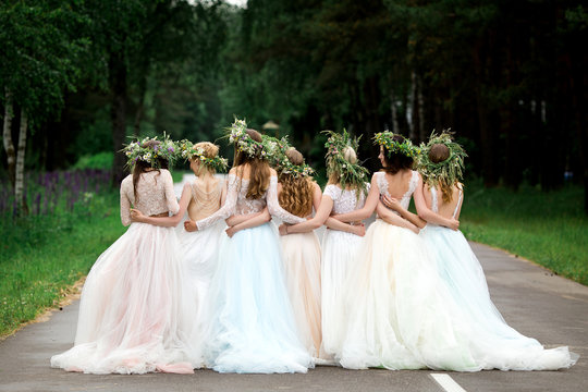 Wedding. The bride in a white dress standing and embracing bridesmaids