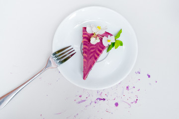 piece of cheesecake with blueberries on a white plate on a white background. view from above