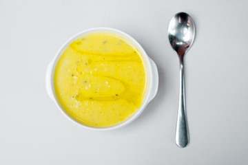 Soup-cheese with broccoli in a white plate on a white background