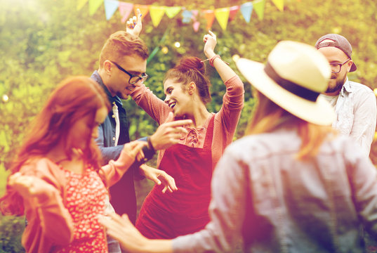 Happy Friends Dancing At Summer Party In Garden