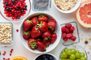 fruits and berries in bowls on table