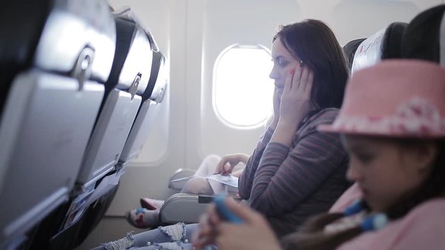 Woman on the plane vomited in a paper bag. Traveler in a flying aircraft has nauseous. Nausea passenger in a flying airplane. Turbulence on the plane.