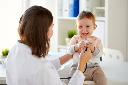 Doctor With Stethoscope And Happy Baby At Clinic