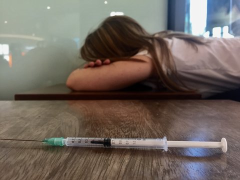 Drug syringe and female victim