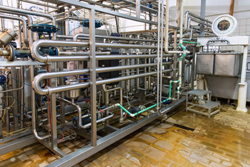 Industrial dairy production. View on the steel pipelines on the milk factory.