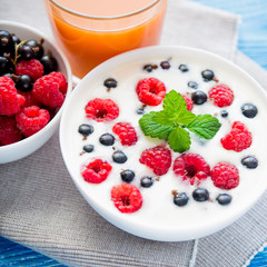 tasty yoghurt with raspberry on wood blue table