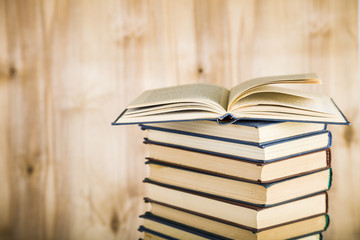 Stack of books on a wooden background.