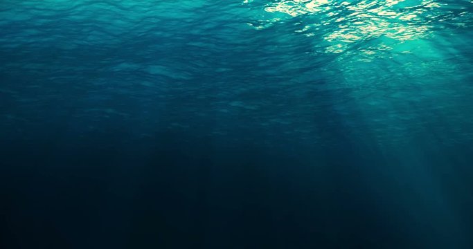 perfectly seamless loop of deep blue caribbean ocean waves from underwater background, light rays shining through