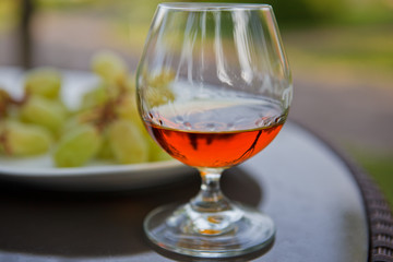 Cognac in a glass with grapes