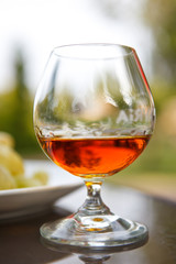 Cognac in a glass with grapes