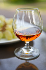 Cognac in a glass with grapes