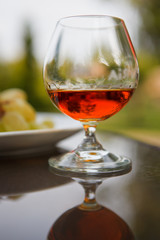 Cognac in a glass with grapes
