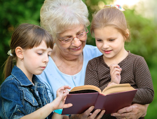Fototapeta premium education concept, grandmother reading a book for grandchildren
