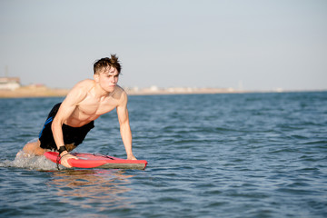 Fototapeta premium Teenage boy with a body board in the sea