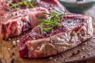 Beef raw steak. Raw fresh T-bone steak with salt pepper and rosemary