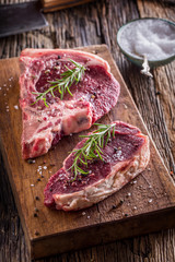 Beef raw steak. Raw fresh T-bone steak with salt pepper and rosemary