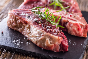 Beef raw steak. Raw fresh T-bone steak with salt pepper and rosemary