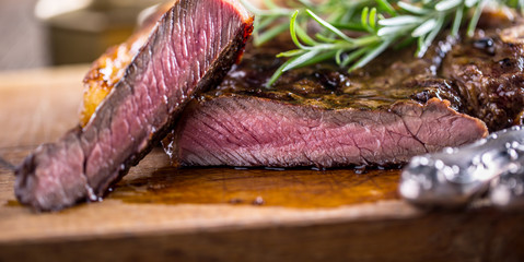 Grill juicy beef T-bone steak with salt pepper and rosemary
