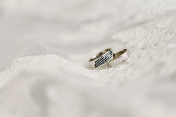 two wedding wedding rings on a neutral white curtain lace background