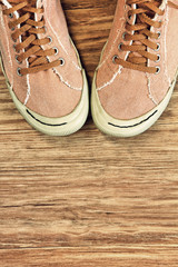 Retro style Gym shoes on wooden background with empty space.