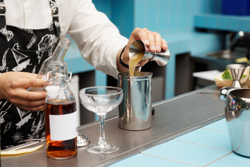 Bartender is pouring infusion into a mixing glass