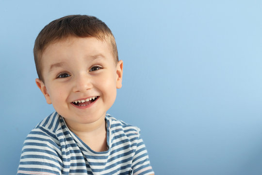 ni&ntilde;o peque&ntilde;o sonriendo en un fondo azul con espacio para copia