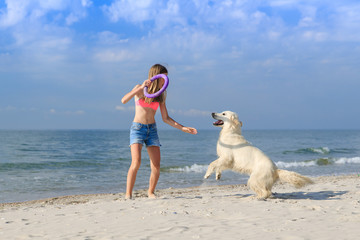 happy girl playing with a dog on the beach