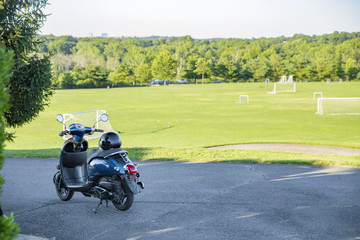 motorcycle parked near a football field. motor scooter on the background of sports field