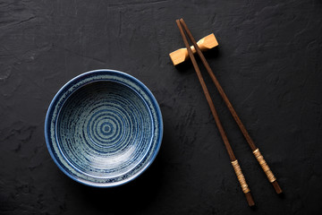  ceramic dish (plate) and chopsticks on dark table © Hyper Bee