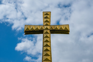 golden cross isolated on sky background - christianity