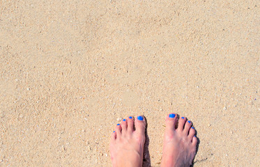 Woman feet on white sand. White coral beach by sea. Sunny tropical seaside.