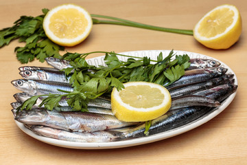 Fototapeta na wymiar Mediterranean anchovies with parsley and lemon. Cooking Mediterranean food