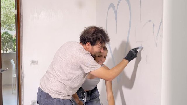 Man writing I love you on home wall for girlfriend smiling happy medium shot 4k slow motion