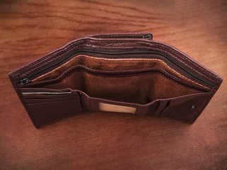 Empty purse on a wooden background; Open women's wallets