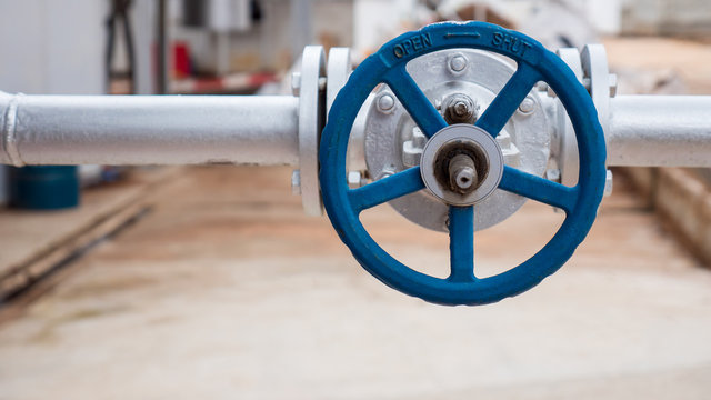 Close up of manual operate ball valve at factory. Pipes and valves industrail equipment.