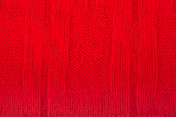 Sweater or scarf fabric texture large knitting. Knitted jersey background with a relief pattern. Wool hand- machine, handmade. red.