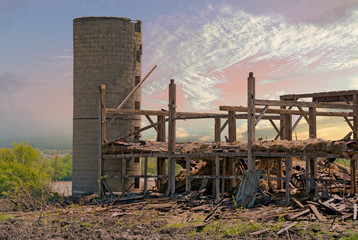 Fototapeta na wymiar farm silo with demolished old wooden barn in morning light