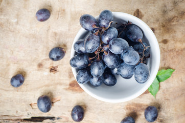 Red grapes in a bowl on wooden,Healthy fruit