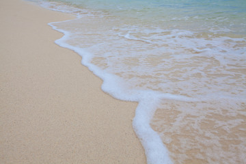 Abstract background of sandy beach with soft waves.