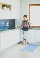 Portrait of smiling woman holding in her hand a yoga mat while standing at studio. Yoga. Woman. Wellness