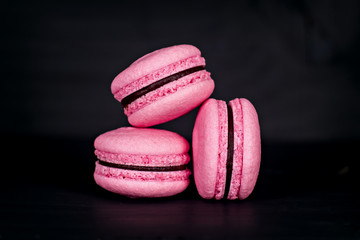 Classic French macaroons on a black background