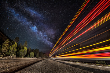 Light streaks on the highway under the Milky Way