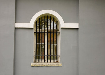 Fototapeta na wymiar Window on the gray brick wall of old building