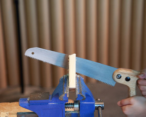 Hand saw sawing through wood block © CJH Photography 
