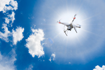 drone flying with Sun and blue sky on the background , lens flare effect.
