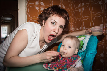 Mother feeds the baby baby puree