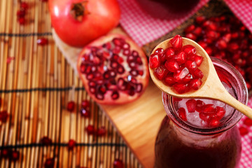 Pomegranate Set. Good healthy by Pomegranate seed on wooden spoon and cool Pomegranate juice set on red Themes tone background. have some space for write wording