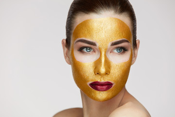 Cosmetology Mask. Young Woman With Gold Face Mask On Soft Skin