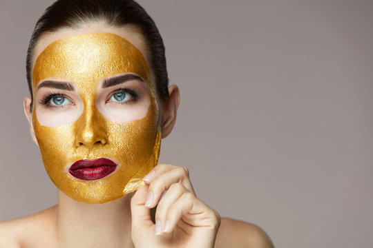 Beauty Product. Closeup Of Sexy Woman Removing Golden Mask